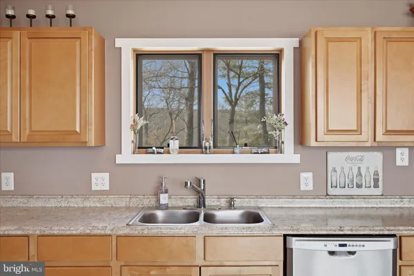 a bathroom with a granite countertop sink mirror and a shower