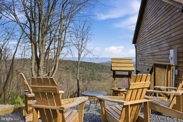 a picture of a living room with a floor to ceiling window and stairs