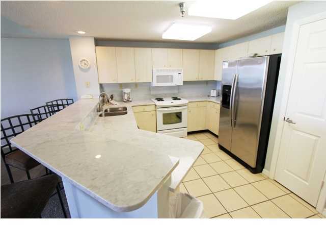 3668 County Road, Unit 101 Santa Rosa Beach, FL 32459 - Photo 10 of 33 a kitchen with stainless steel appliances granite countertop a refrigerator a sink a stove a microwave and island