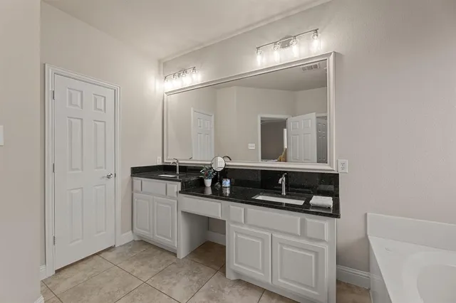 a bathroom with a double vanity sink and mirror