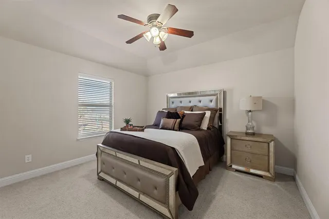 a spacious bedroom with a bed and a ceiling fan