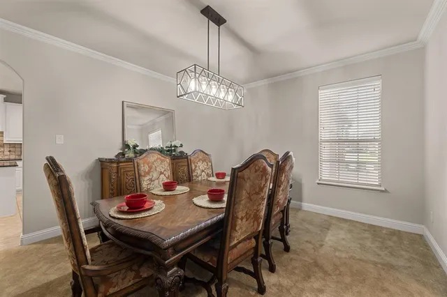 a dining room with furniture a chandelier and window