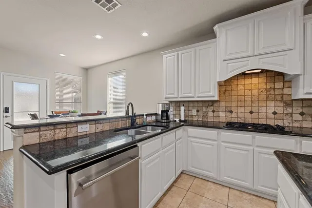 a kitchen with stainless steel appliances granite countertop a sink a stove and cabinets