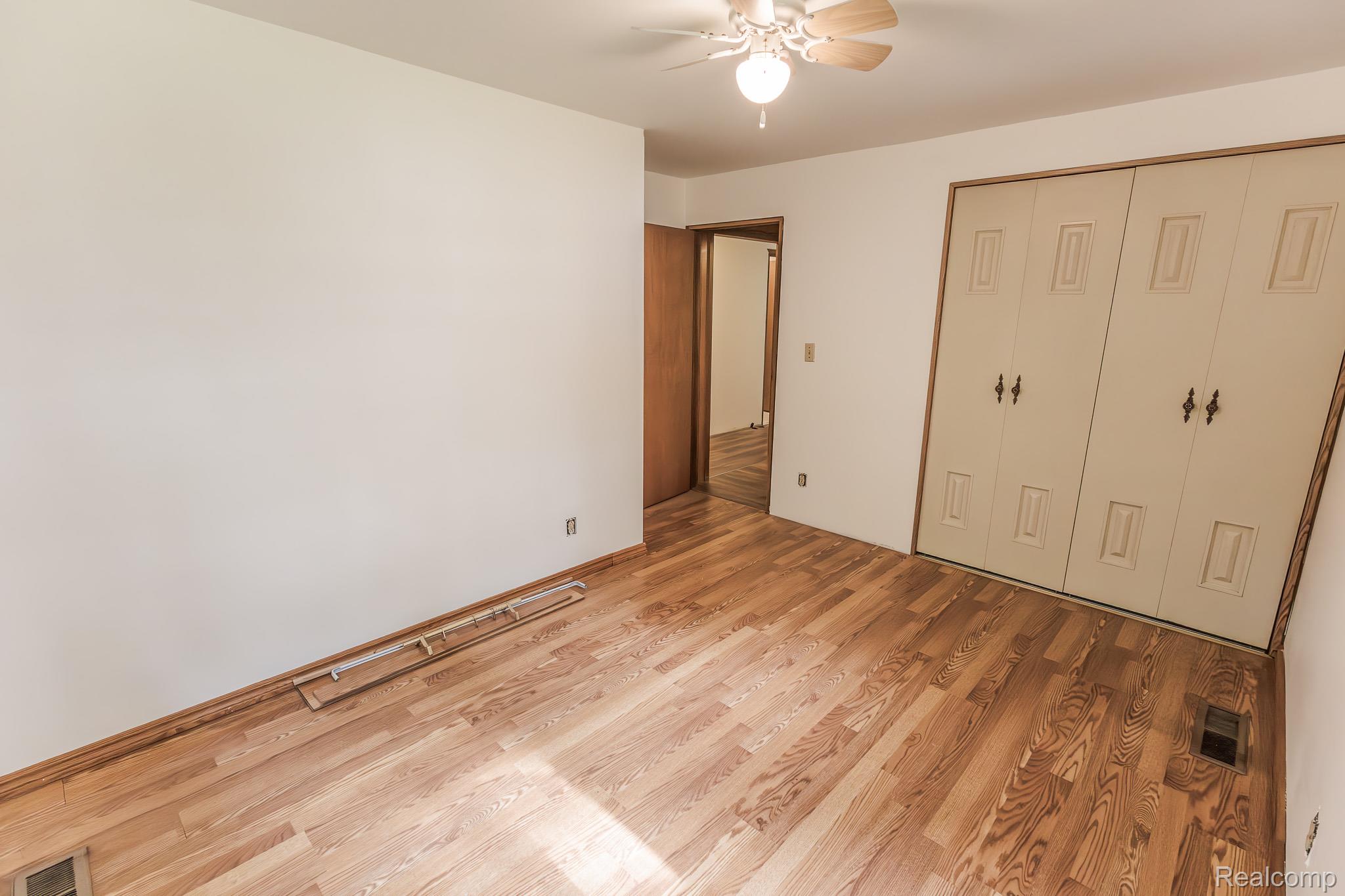7800 Oak Road Millington, MI 48746 - Photo 20 of 32 Hardwood flooring with natural finish, ceiling fan with integrated lighting, and bi-fold closet doors