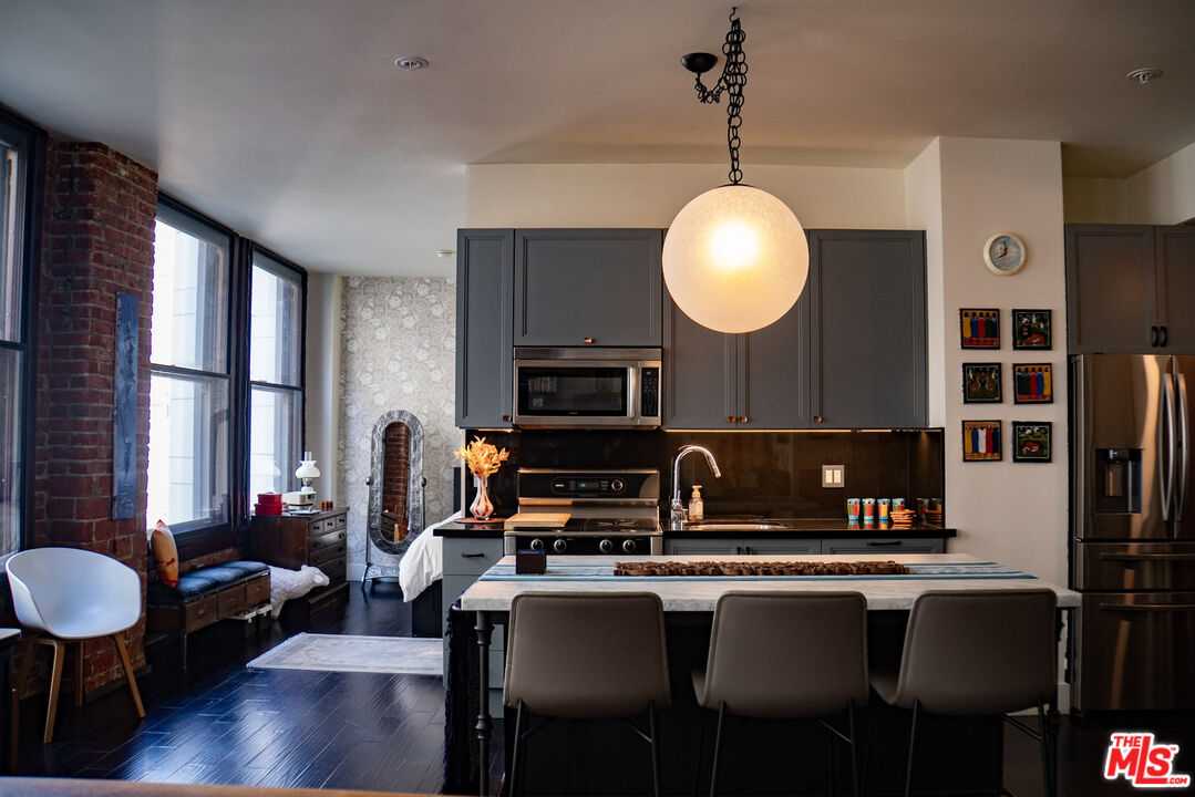 460 South Spring Street, Unit 514 Los Angeles, CA 90013 - Photo 12 of 50 a kitchen with a table chairs sink and cabinets