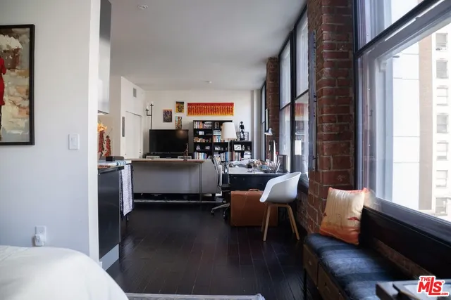 a living room with furniture wooden floor and a large window