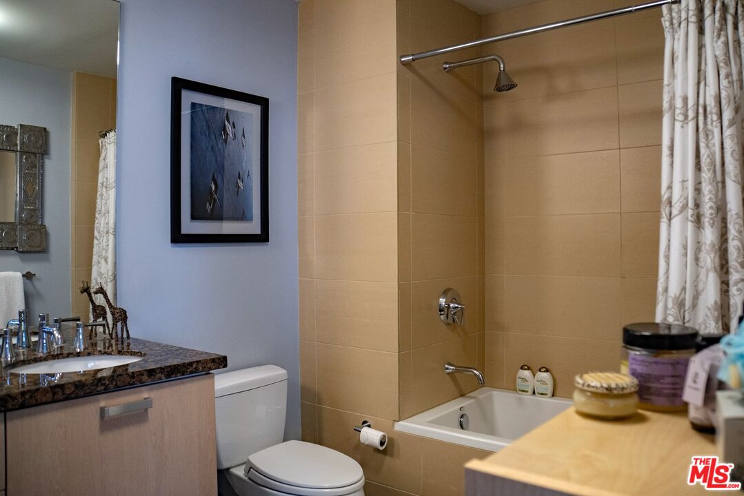 460 South Spring Street, Unit 514 Los Angeles, CA 90013 - Photo 10 of 50 a bathroom with a granite countertop sink toilet and a mirror