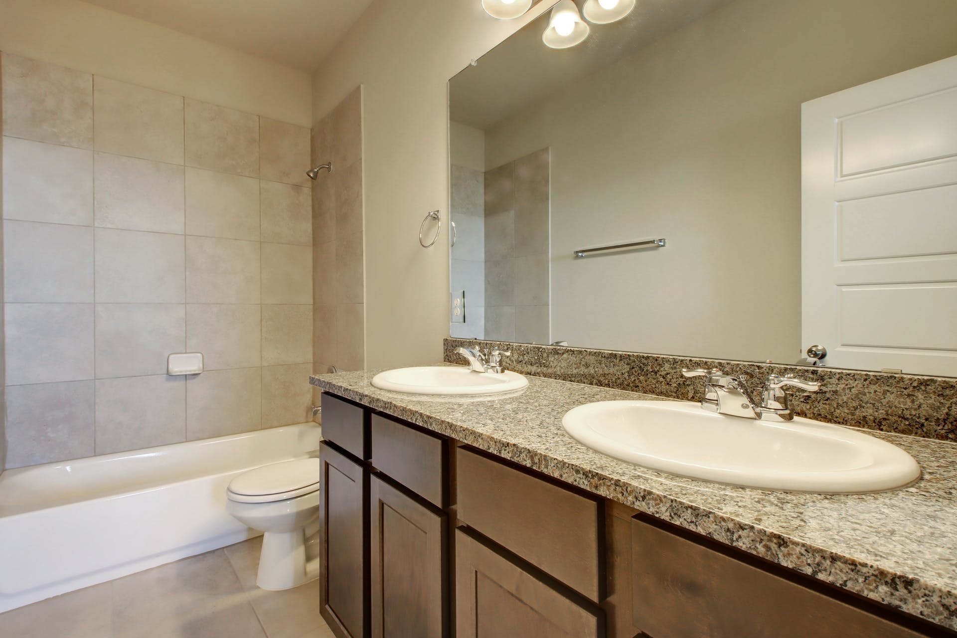 1202 Garland Road Georgetown, TX 78626 - Photo 21 of 28 Bathroom featuring a dual vanity with granite-finish countertop, undermount sinks, and dark wood cabinetry