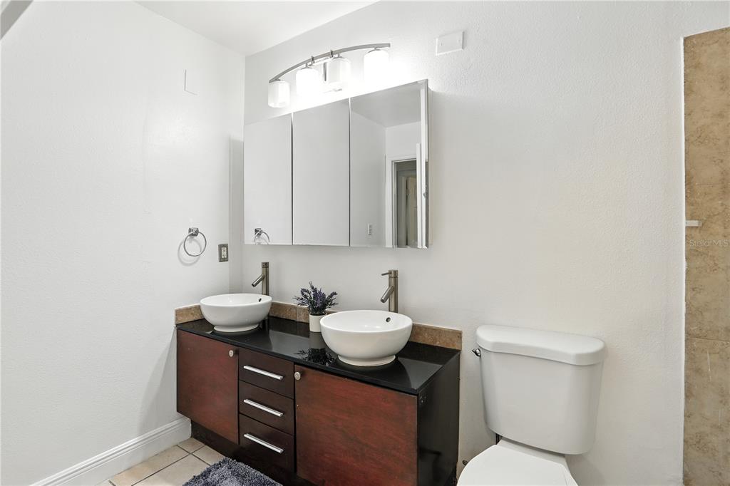 1695 Lee Road, Unit D113 Winter Park, FL 32789 - Photo 16 of 34 a bathroom with a toilet a sink and mirror