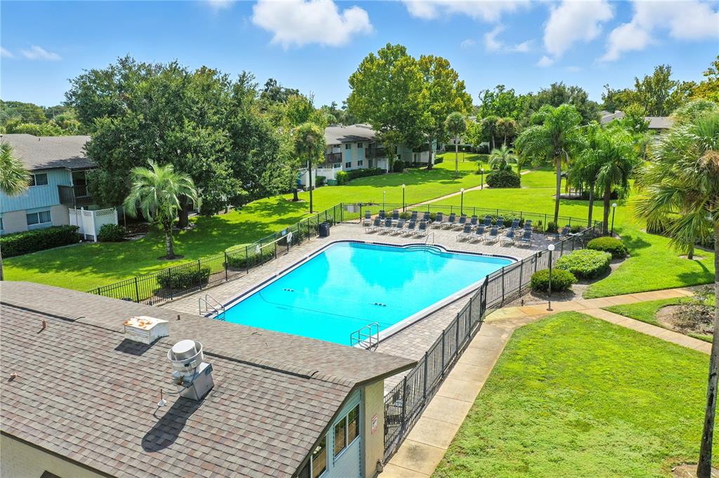 1695 Lee Road, Unit D113 Winter Park, FL 32789 - Photo 24 of 34 a view of a swimming pool with a garden and trees