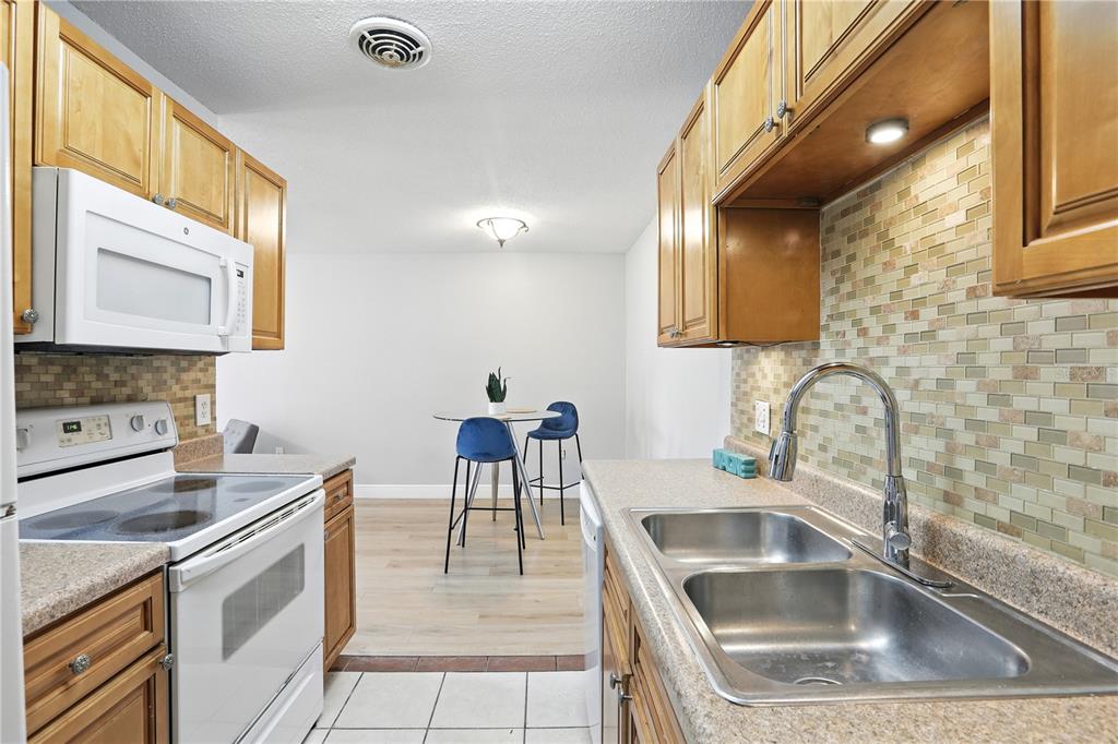 1695 Lee Road, Unit D113 Winter Park, FL 32789 - Photo 3 of 34 a kitchen with a sink and a stove top oven