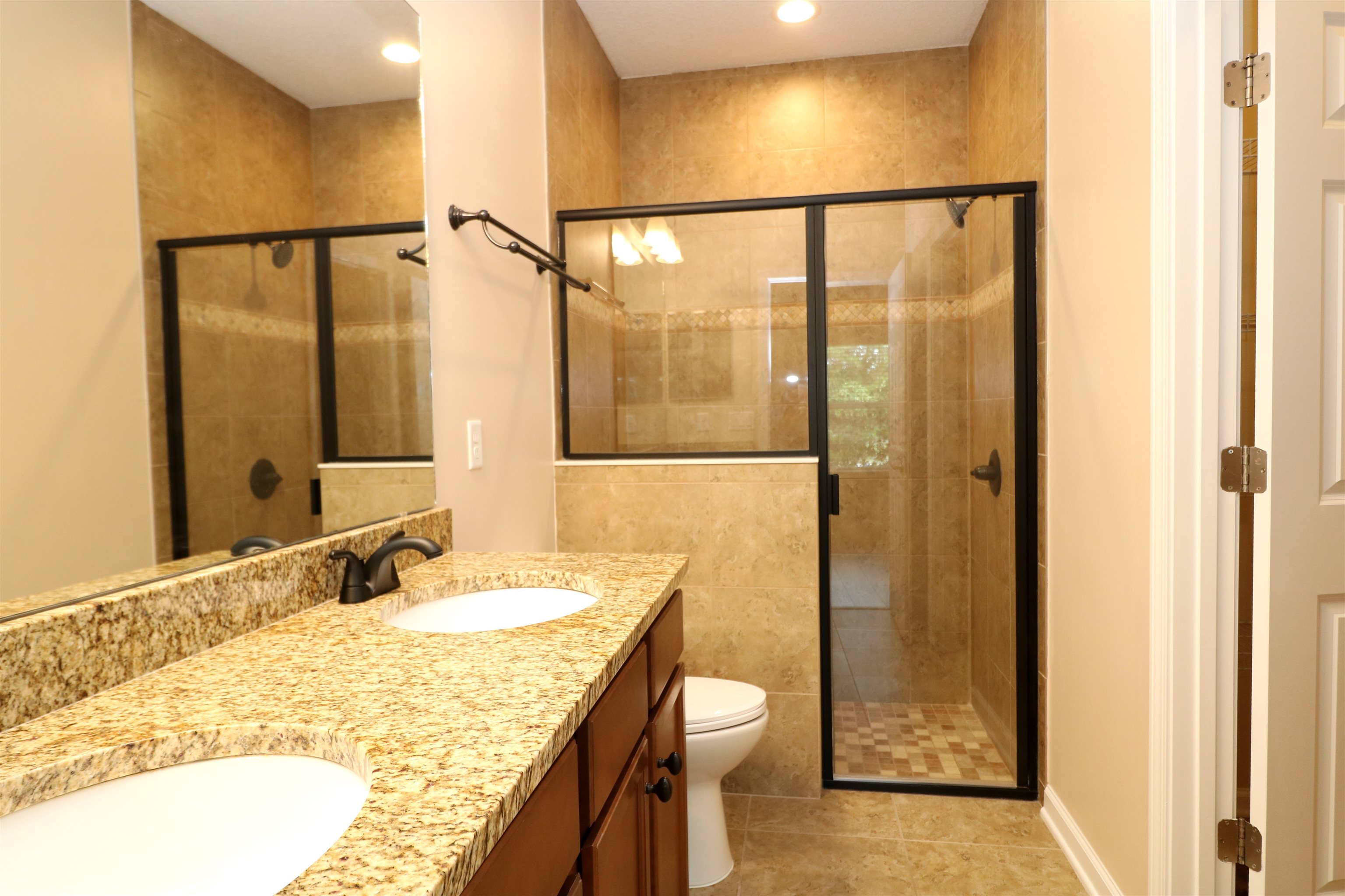 189 Amistad Drive St. Augustine, FL 32086 - Photo 15 of 47 a bathroom with a granite countertop sink a toilet and shower