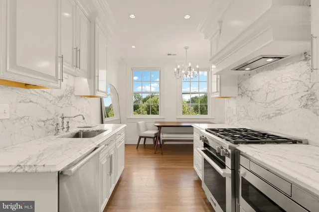 a kitchen with stainless steel appliances granite countertop a sink stove and cabinets