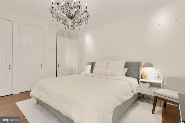 a bedroom with a bed and a chandelier