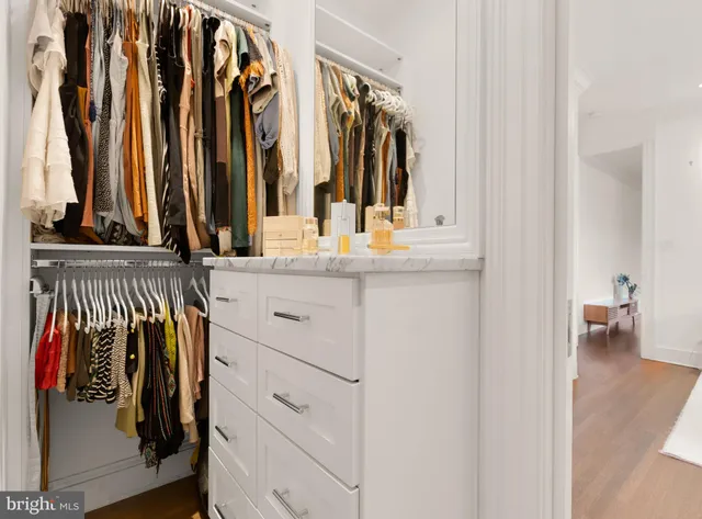 a view of walk in closet with clothes and shoes