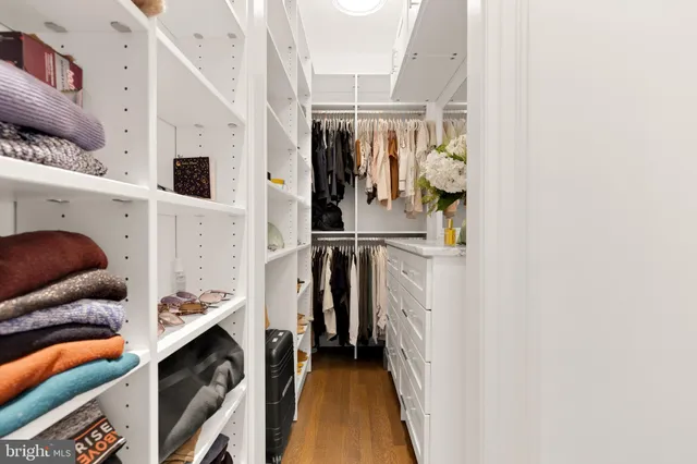 a view of walk in closet with clothes and shoes
