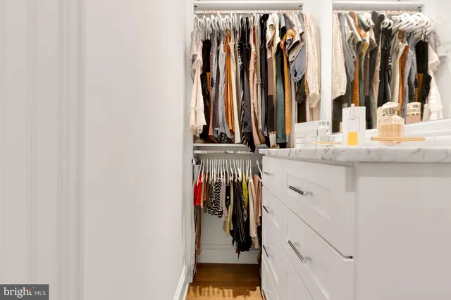 a view of walk in closet with clothes