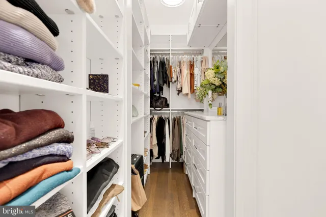 a view of walk in closet with clothes and shoes