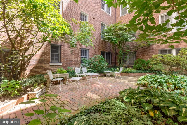 a view of a house with brick walls and a yard with plants