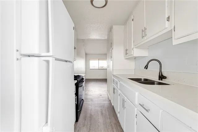 a kitchen with white cabinets and sink