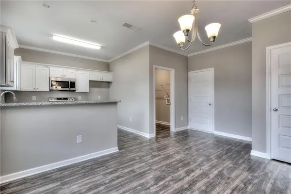 a view of kitchen with granite countertop cabinets and refrigerator