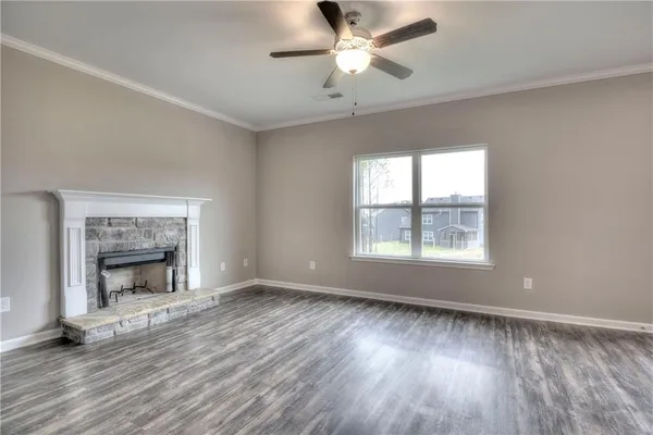 wooden floor fireplace and windows in an empty room