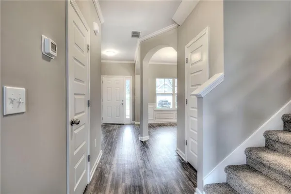 a view of a hallway with wooden floor and staircase