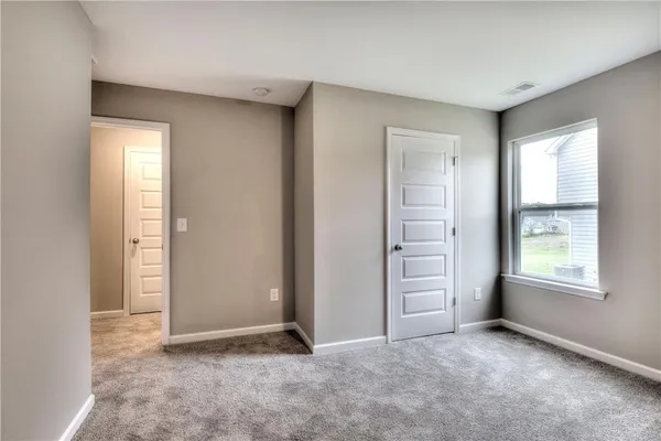 an empty room with windows and closet