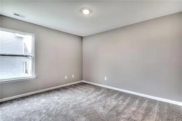 an empty room with closet and mirror