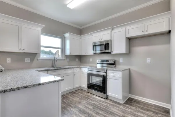 a kitchen with stainless steel appliances granite countertop a stove a sink and a microwave