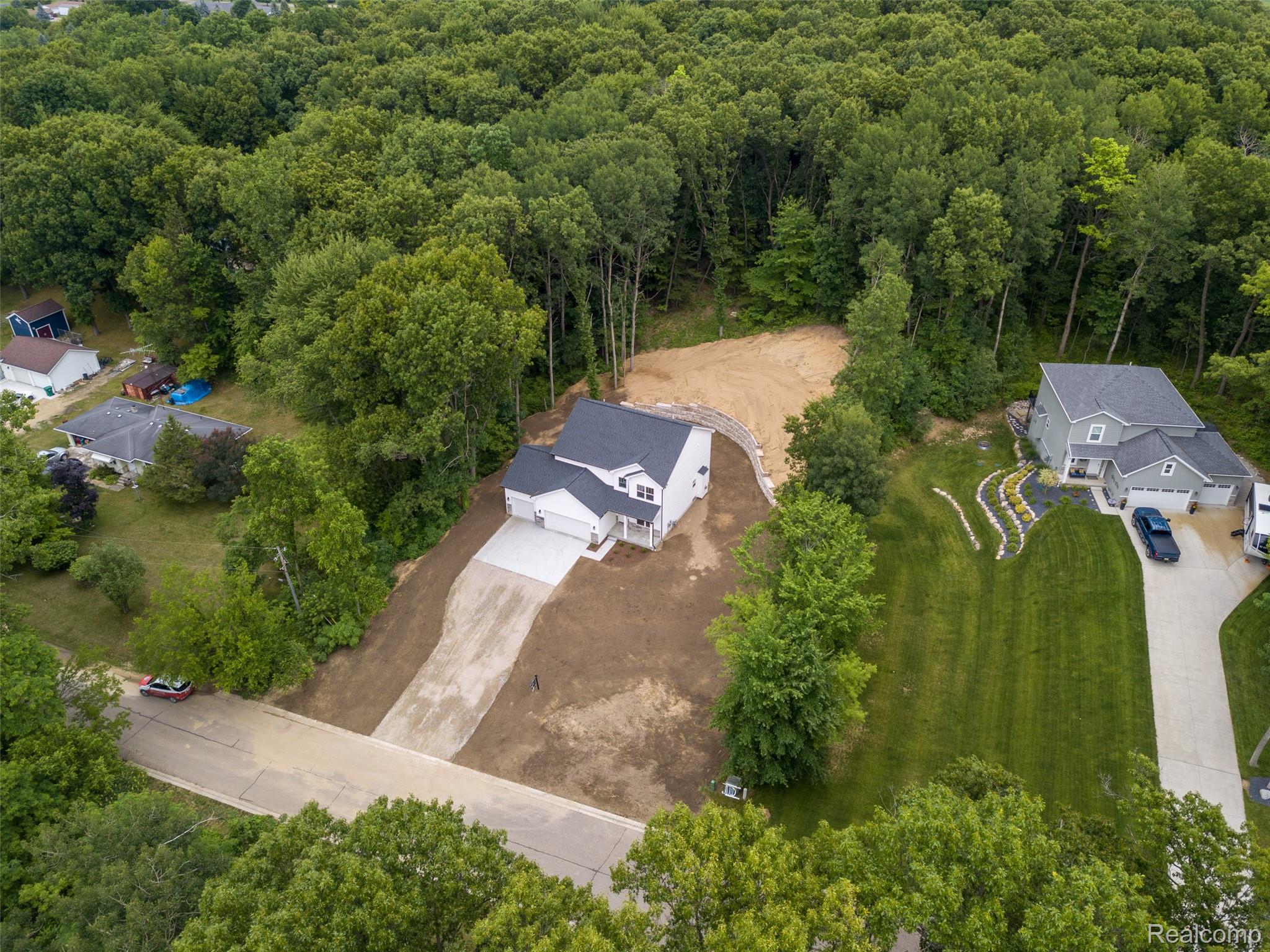 16085 Catalpa Ridge Holly, MI 48442 - Photo 40 of 40 Newly constructed residence featuring a white exterior with a dark roof and an attached two-car garage