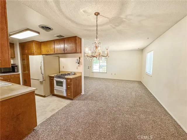 a kitchen with stainless steel appliances kitchen island granite countertop a stove a sink and a refrigerator with wooden floor