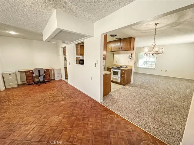 a large kitchen with kitchen island granite countertop a stove a sink dishwasher and a refrigerator with wooden floor