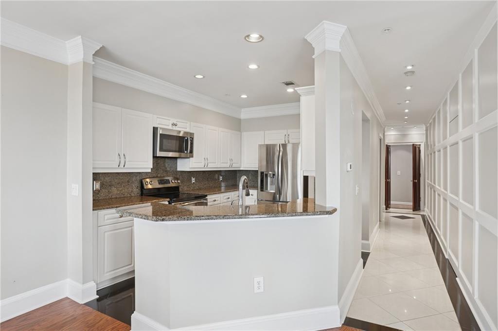 3334 Peachtree Road Northeast, Unit 1109 Atlanta, GA 30326 - Photo 4 of 27 a kitchen with kitchen island stainless steel appliances a sink a stove a microwave a sink a refrigerator and cabinets