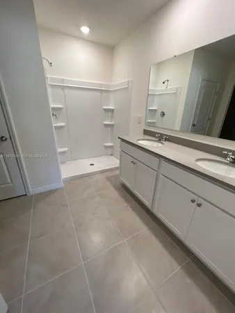 a spacious bathroom with a granite countertop sink a toilet and a mirror