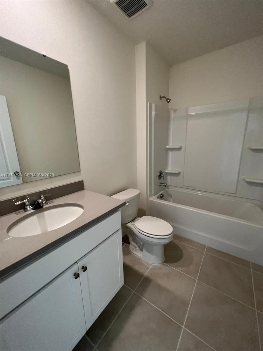 2710 Trinidad Road Haines City, FL 33844 - Photo 5 of 13 a bathroom with a double vanity sink toilet and shower