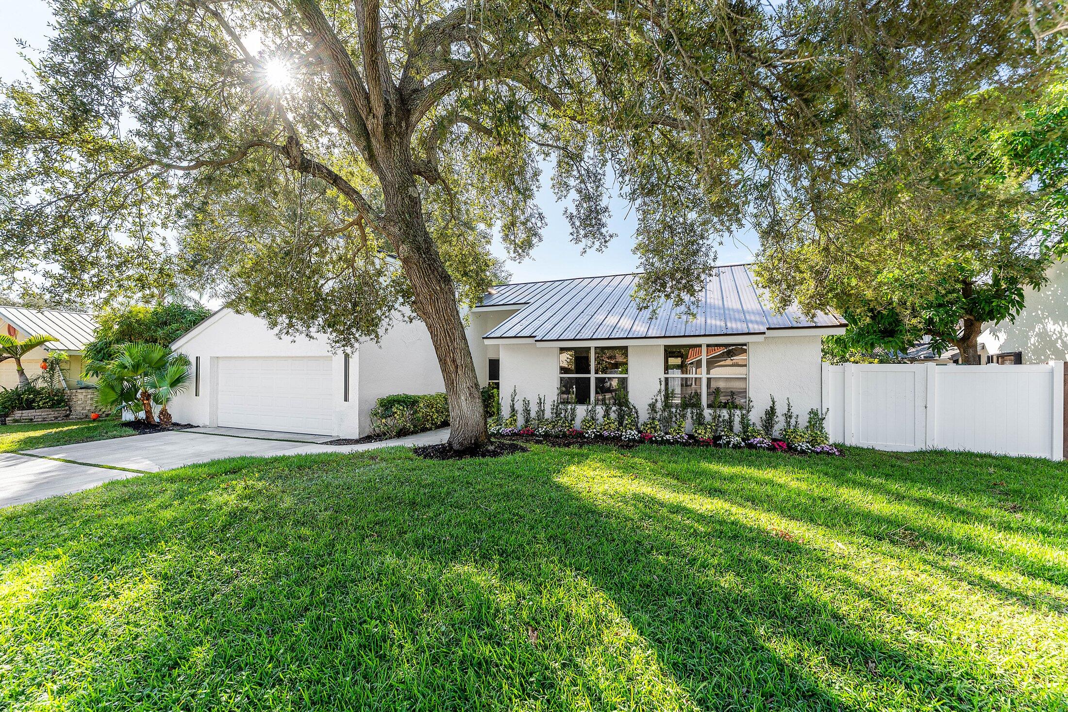 a view of a house with a yard and tree s
