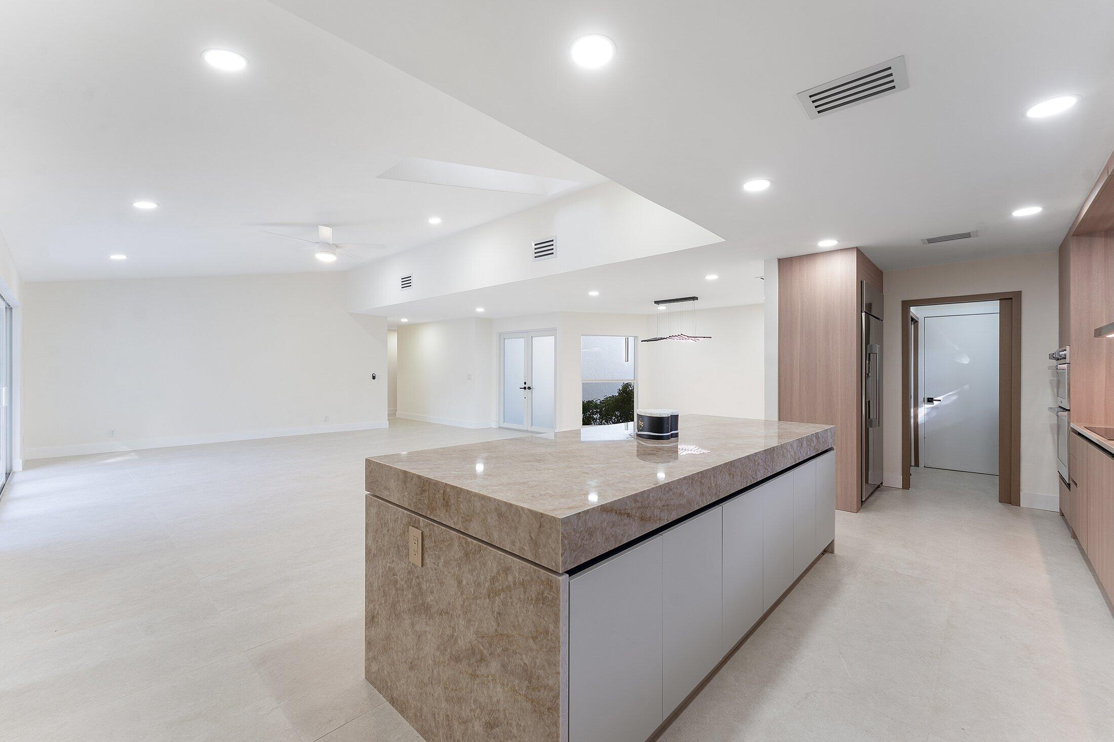 1380 Southwest 1st Street Boca Raton, FL 33486 - Photo 11 of 50 a view of a kitchen island a sink and a refrigerator