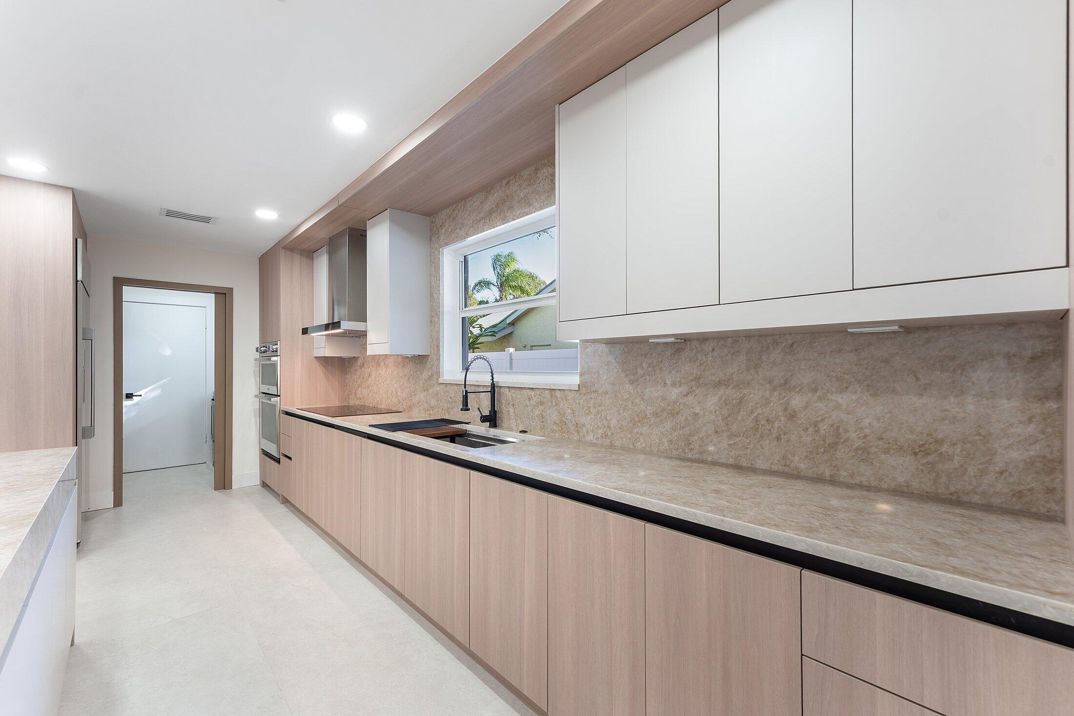 1380 Southwest 1st Street Boca Raton, FL 33486 - Photo 12 of 50 a kitchen with granite countertop white cabinets and a sink