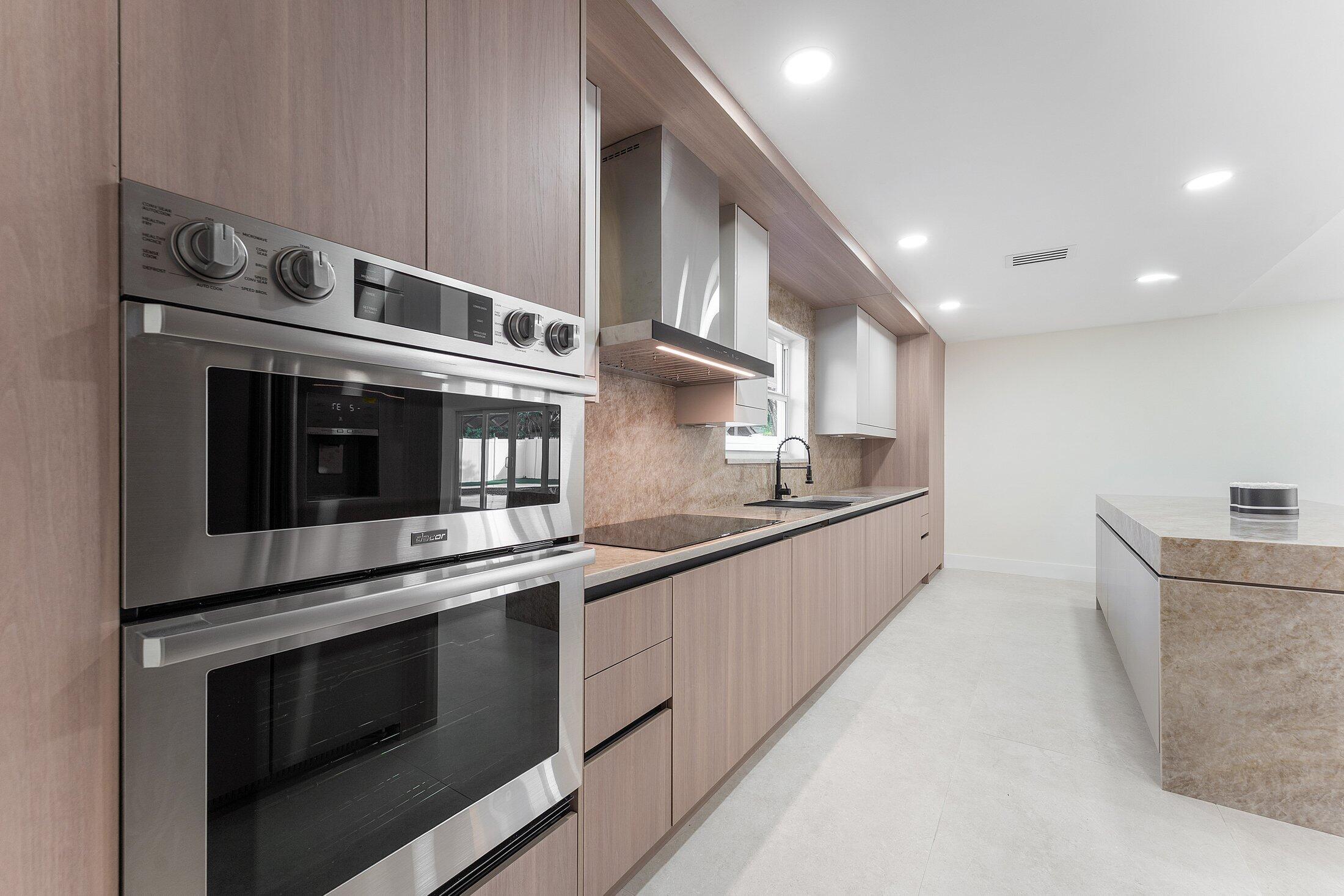 1380 Southwest 1st Street Boca Raton, FL 33486 - Photo 13 of 50 a large kitchen with stainless steel appliances granite countertop a stove and a sink