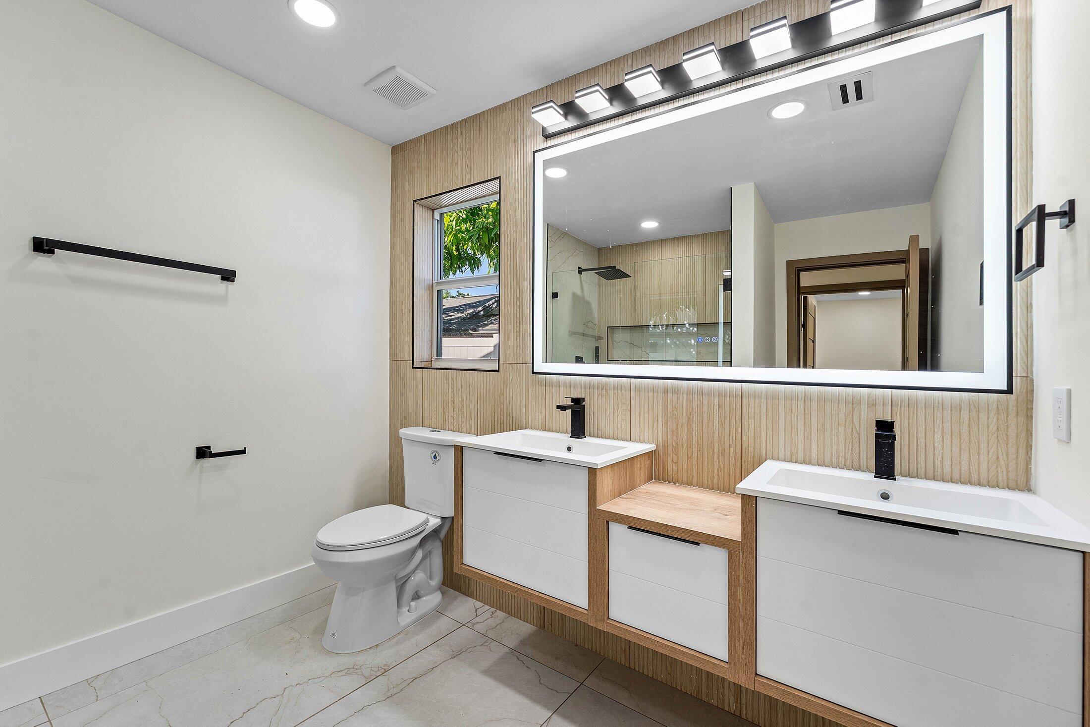 1380 Southwest 1st Street Boca Raton, FL 33486 - Photo 22 of 50 a bathroom with a sink toilet a mirror and vanity