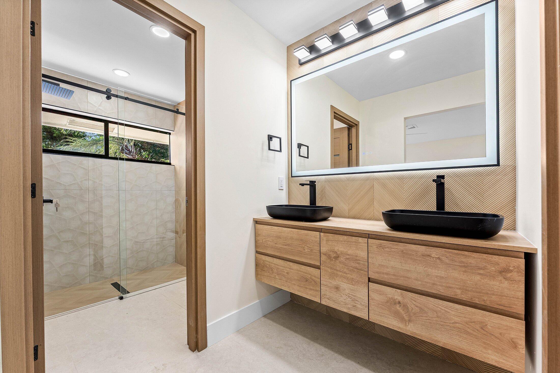 1380 Southwest 1st Street Boca Raton, FL 33486 - Photo 27 of 50 a bathroom with a double vanity sink a mirror and shower