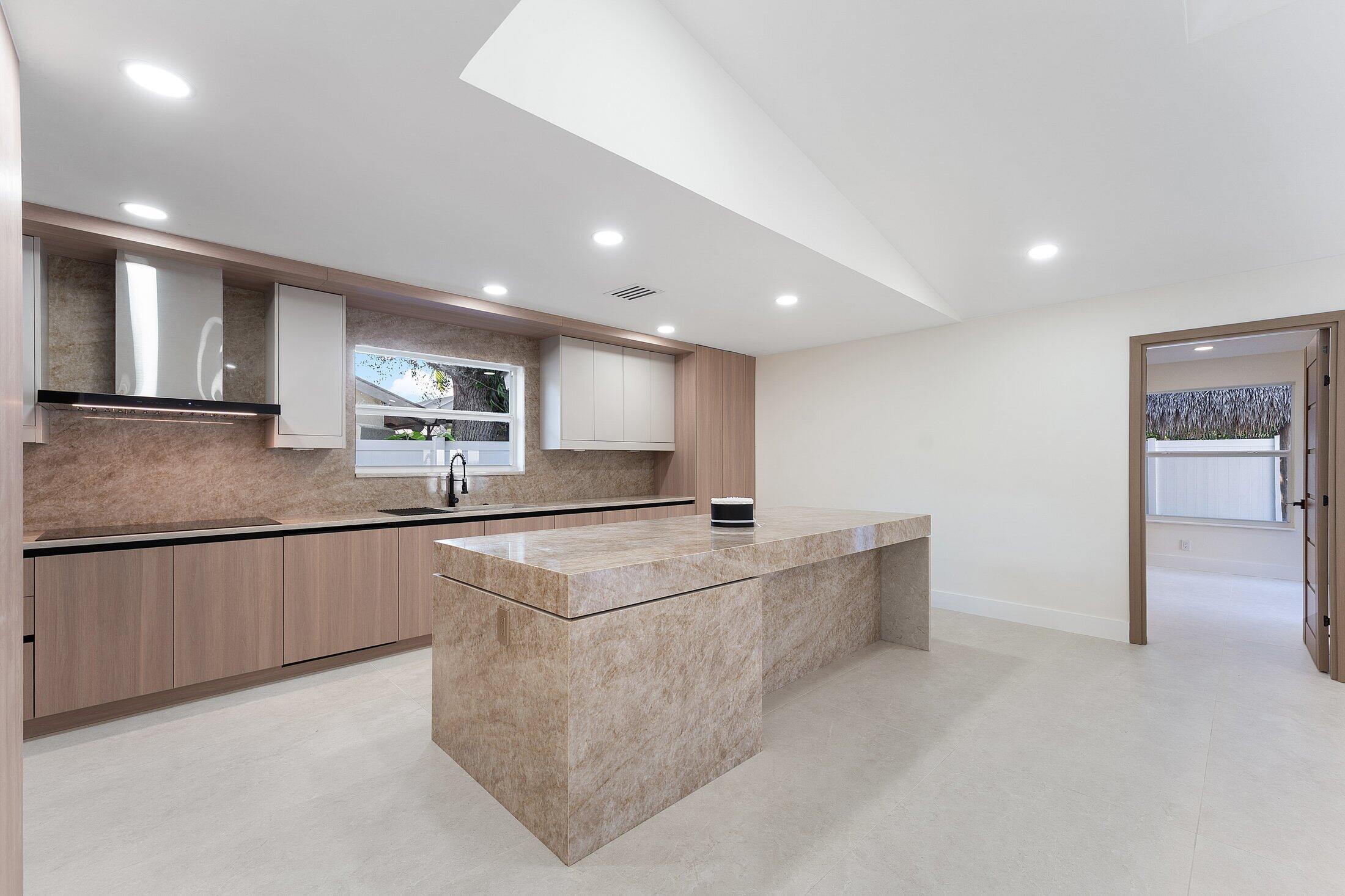 1380 Southwest 1st Street Boca Raton, FL 33486 - Photo 8 of 50 a large white kitchen with kitchen island a sink appliances and a counter top
