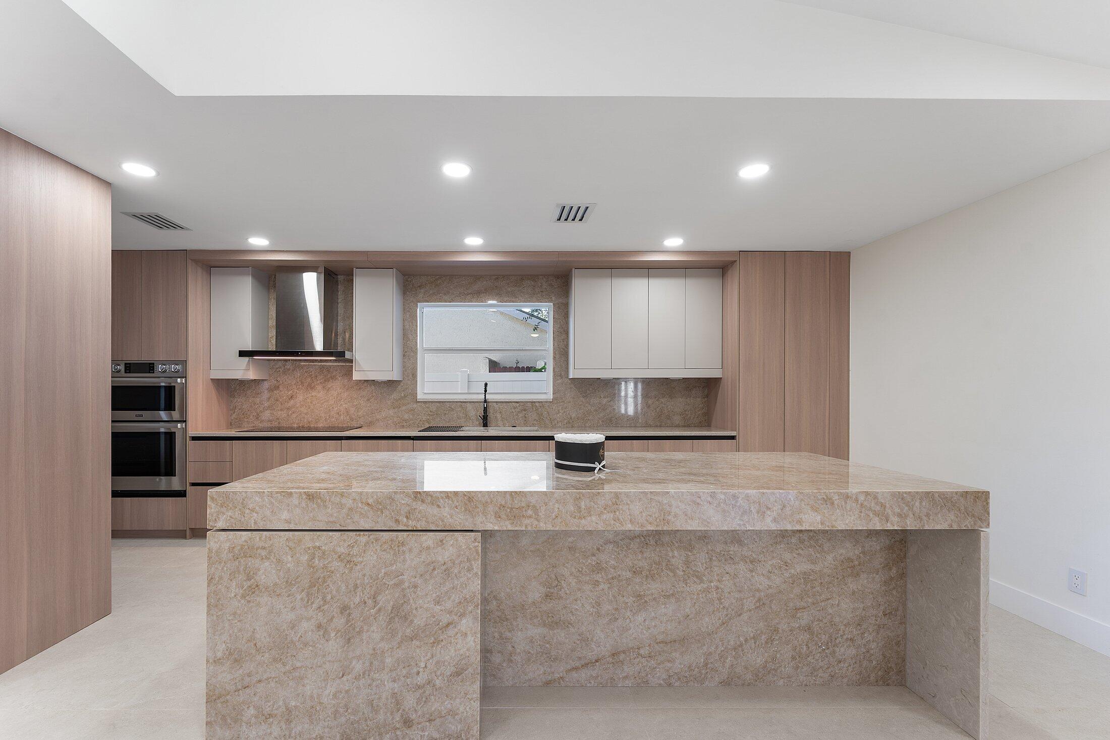 1380 Southwest 1st Street Boca Raton, FL 33486 - Photo 9 of 50 a large white kitchen with kitchen island a sink stainless steel appliances and cabinets