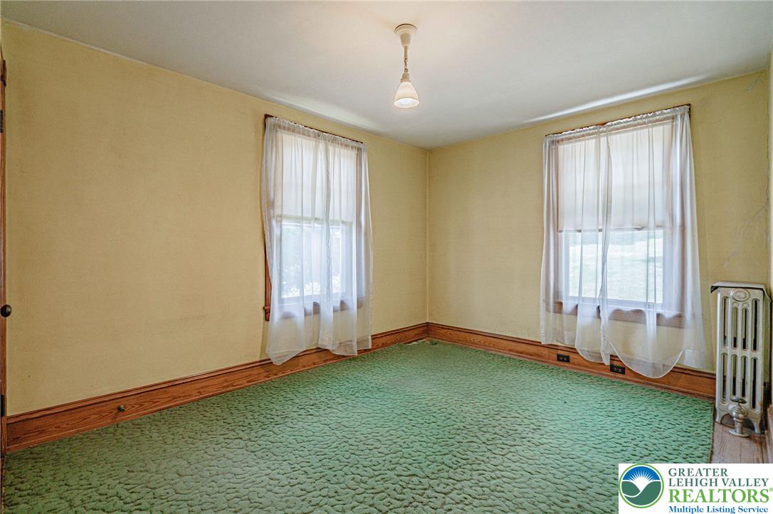 159 West Ridge Street Nesquehoning, PA 18240 - Photo 20 of 55 A well-lit room awaits your personal touch with vibrant green carpeting and warm wooden trim.