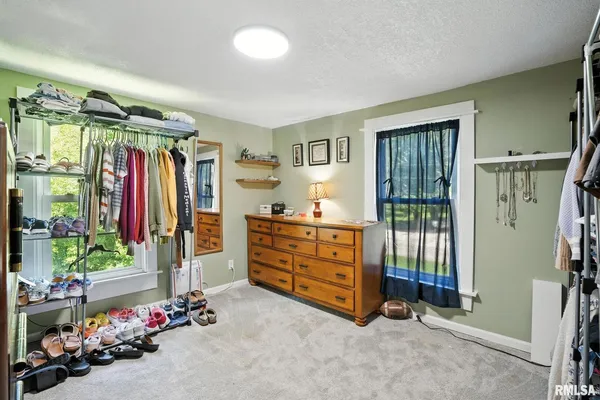 a view of a bedroom with baby crib and furniture