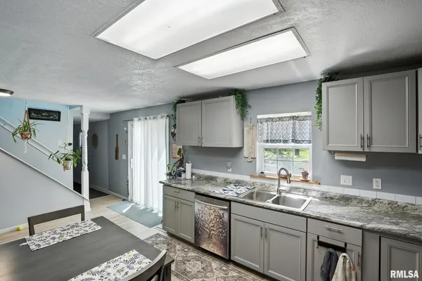 a kitchen with granite countertop a sink stove and cabinets