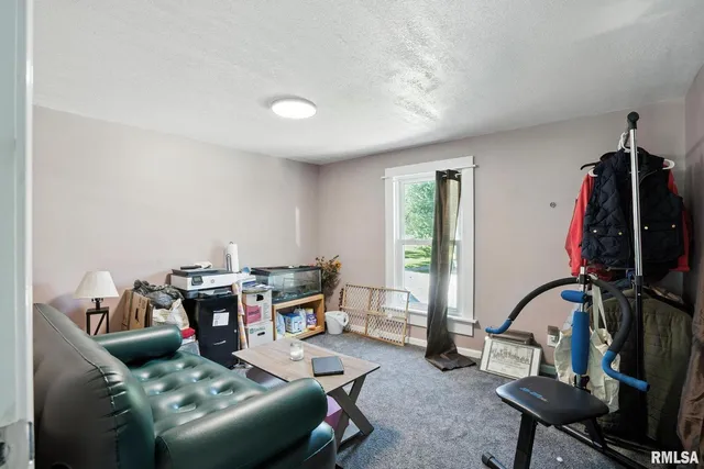 a living room with furniture a rug and white walls