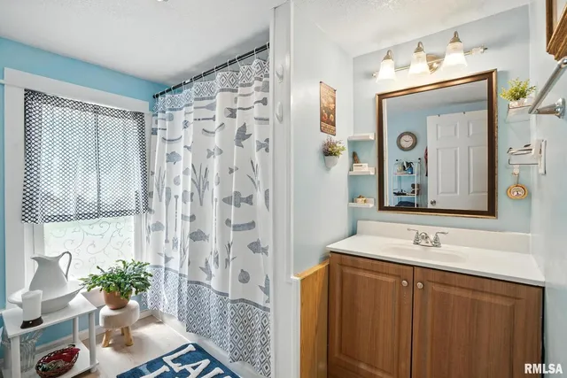 a bathroom with a sink vanity and a mirror