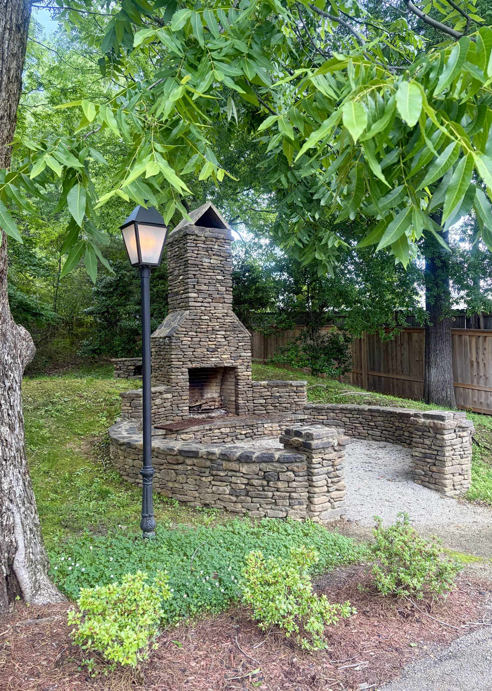 328 Washington Street Collierville, TN 38017 - Photo 32 of 33 Stone outdoor fireplace featuring a hearth and integrated seating